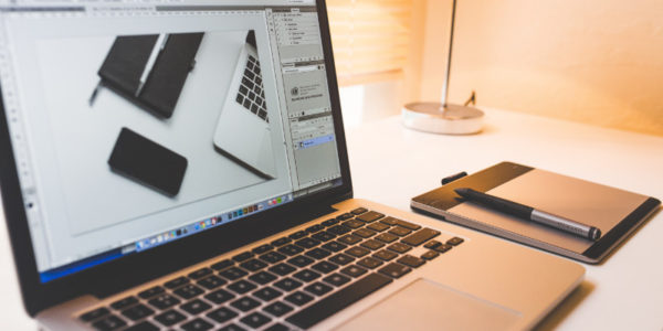 Laptop on desk with image editing program open