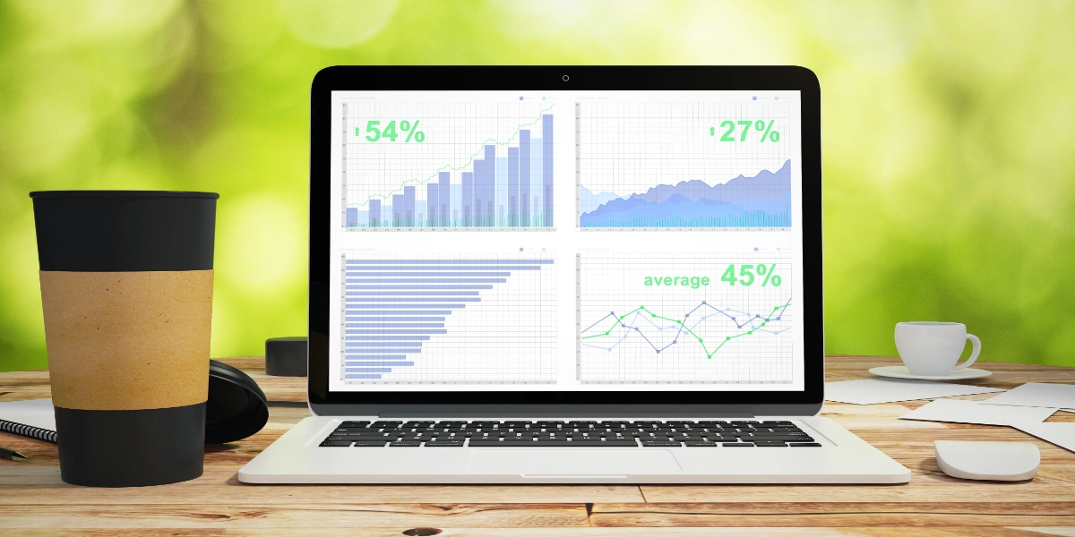 Laptop with analytical graph on wooden table